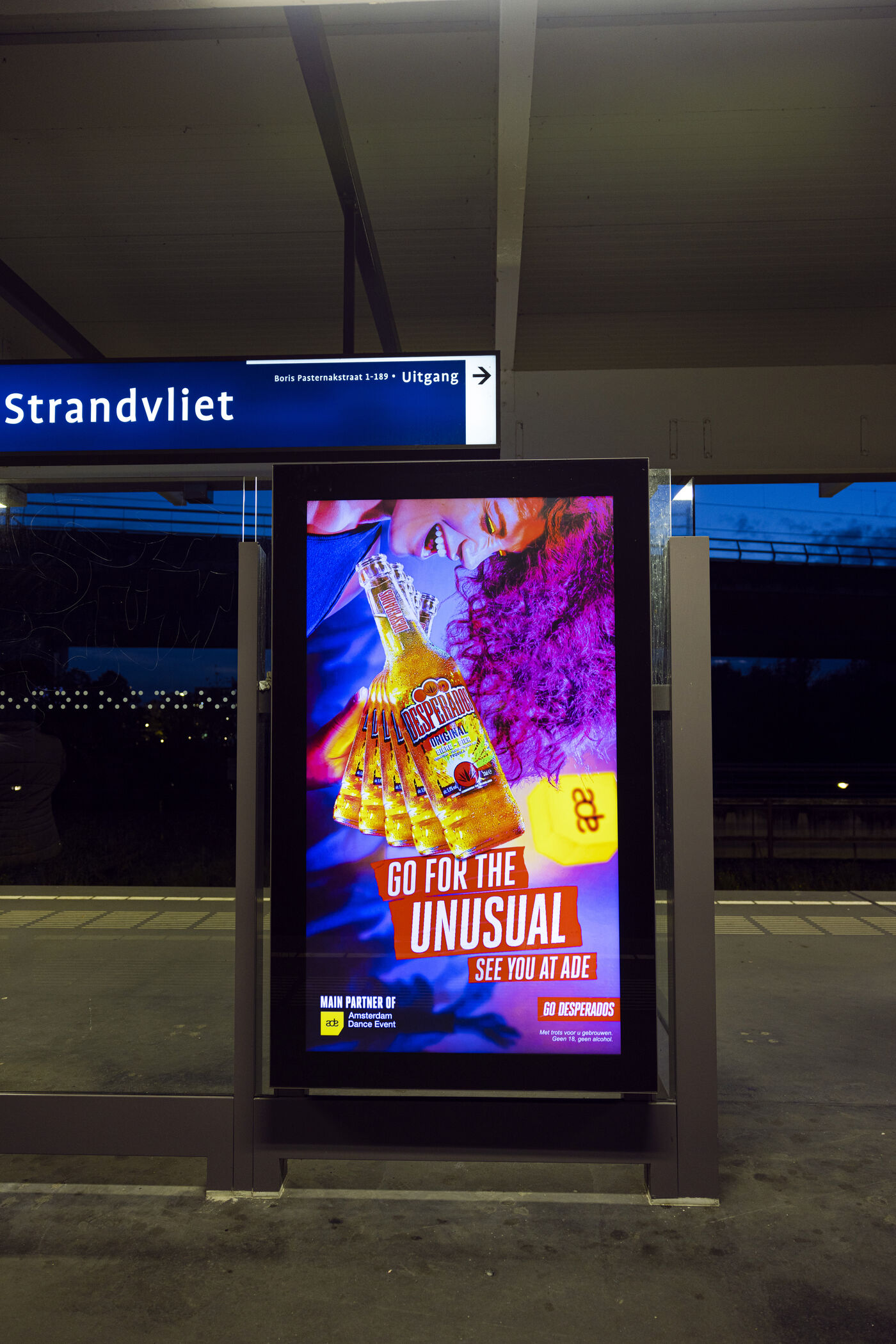 Digital screen at a transit stop at night