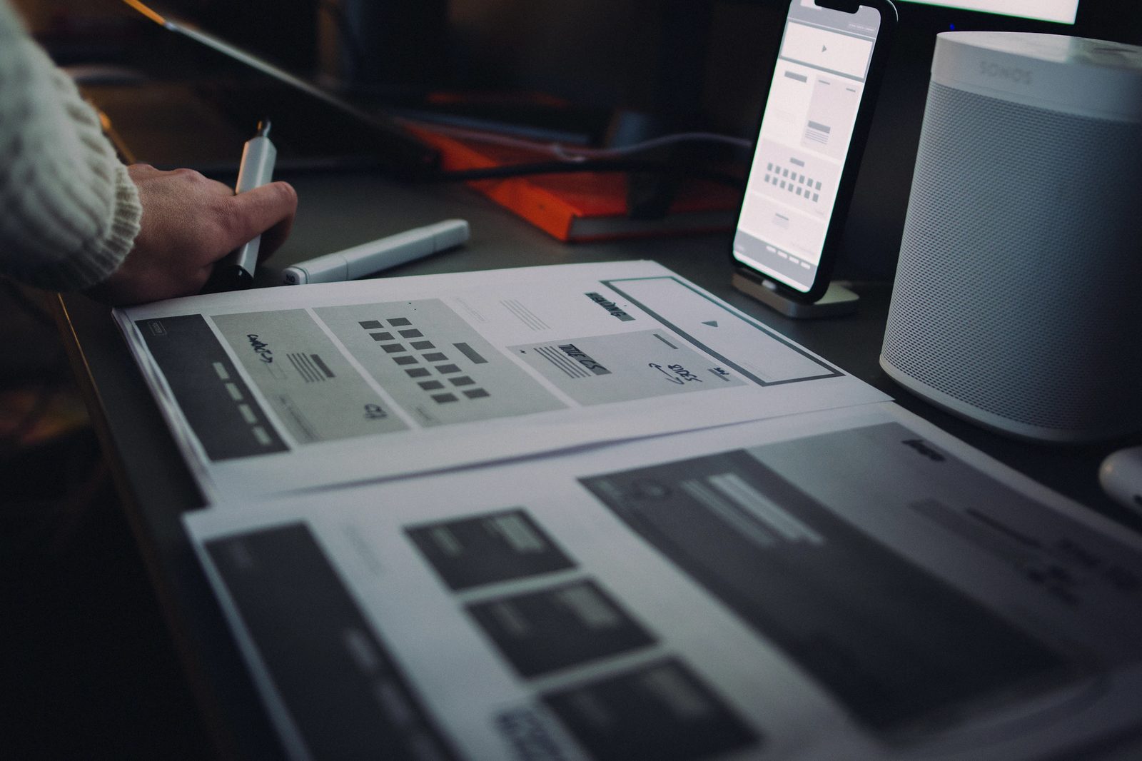 Printed wireframes on the desk during the design process
